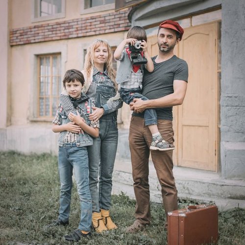 Famille souriante devant la maison